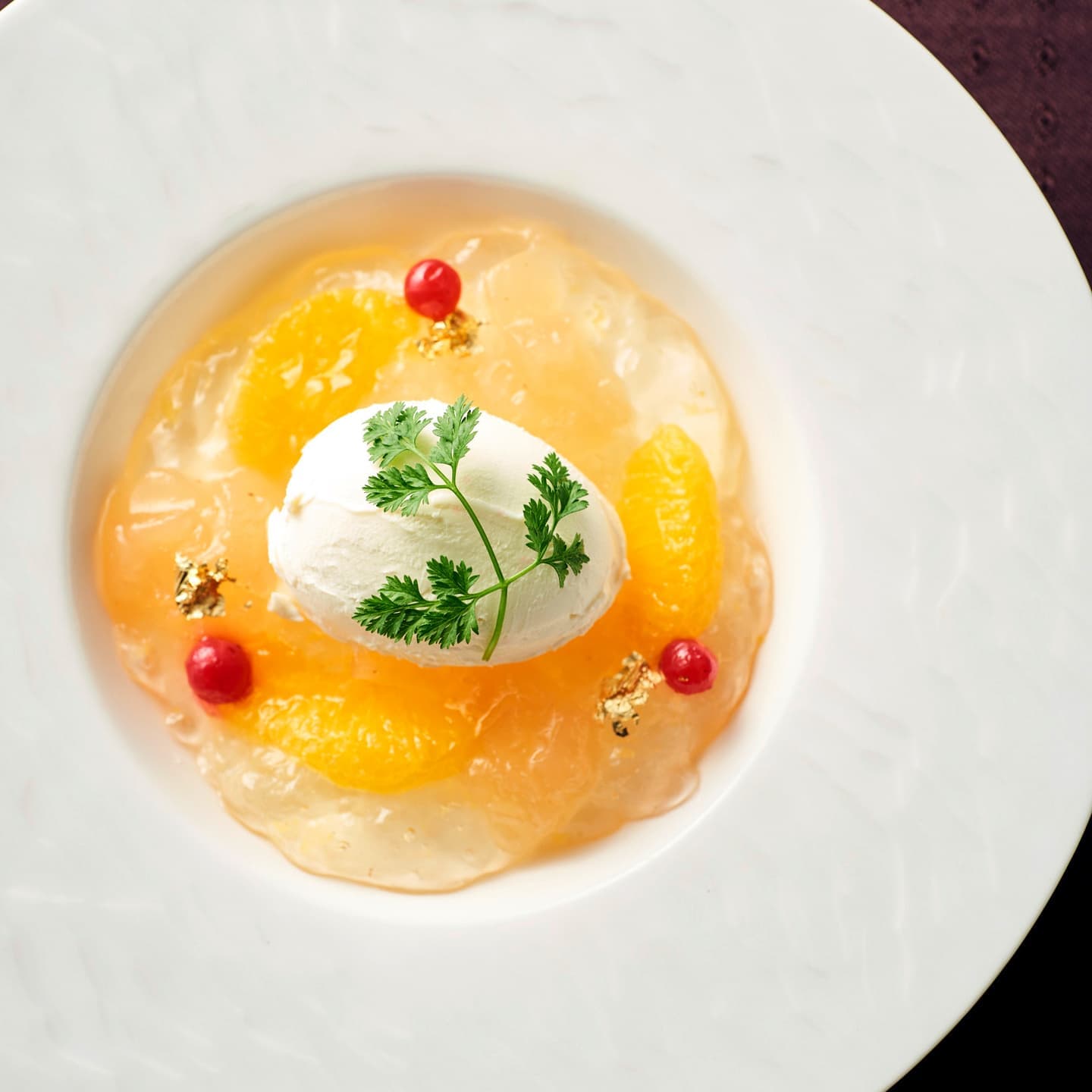 金箔を添えたオレンジのジュレとバニラアイスクリームのデザート、真上からのアングルで瑞々しさと色彩を際立たせたスイーツ撮影