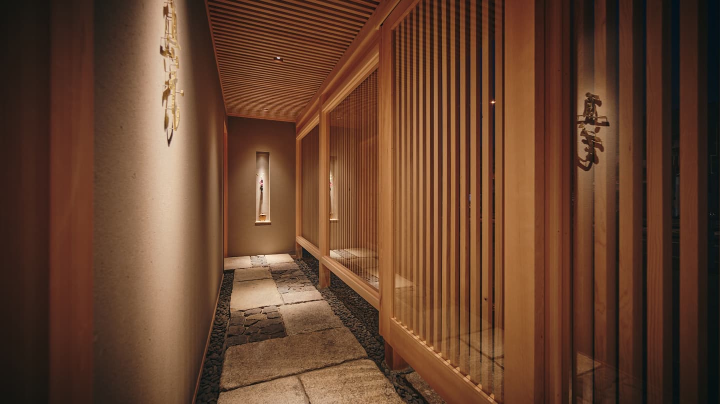 打ち水された石畳と格子戸が続く高級和食店の情緒ある廊下、奥行きと陰影を活かした静謐な空間撮影