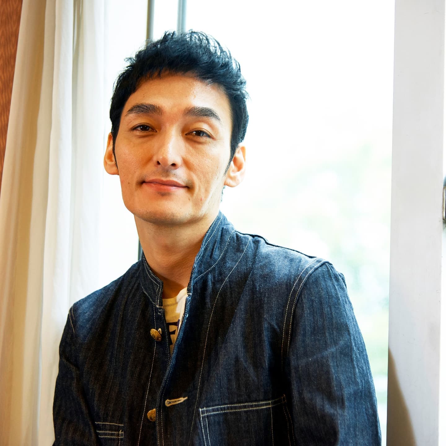 窓際からの自然光を活かしたナチュラルな人物ポートレート。被写体の誠実さとブランドの透明感を伝えるライティング技術。